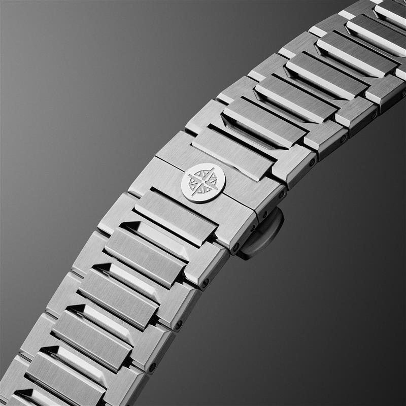 Close-up of a silver watch strap with a brand logo on a dark background